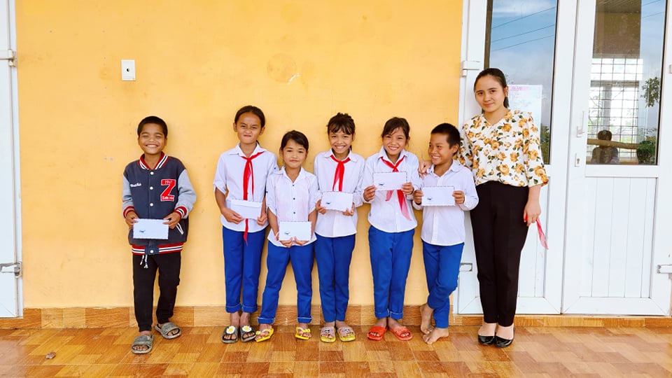 students are lining up with certificates of merit in front of their classroom