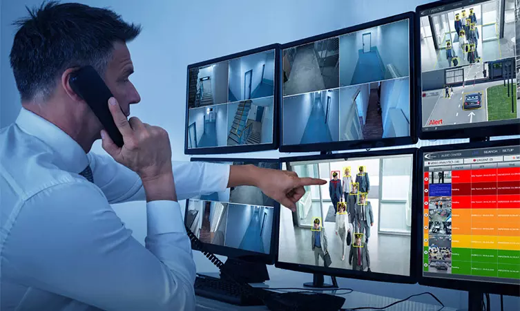 Security operator monitoring Ai alerts on multiple screens