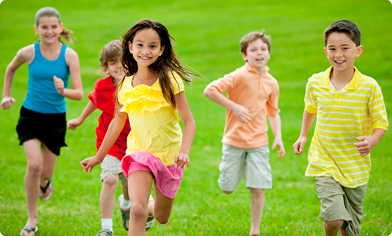 Children running on green grass field outdoors
