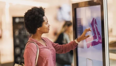 Person interacting with a touchscreen mall directory in a public indoor space