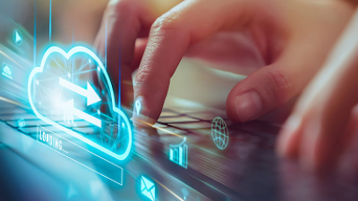 Hands typing on keyboard with glowing cloud upload icon